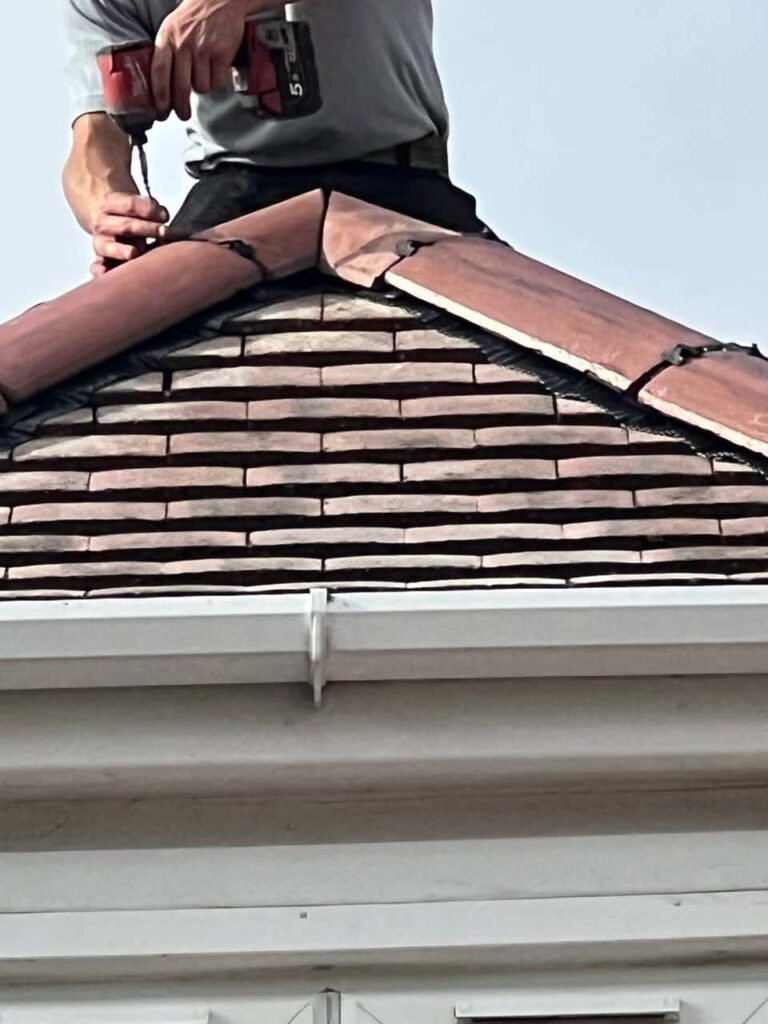 This is a photo of one of the operatives of Heanor Roofing Repairs installing new ridge tiles